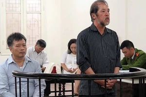 Hai bị cáo Nguyễn Đình Bang và Nguyễn Huy Khang tại một phiên sơ thẩm. (Ảnh: LÊ NHUNG)