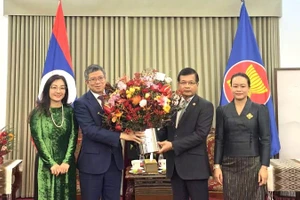 Đại sứ Phạm Thanh Bình tặng hoa chúc mừng Đại sứ quán Lào. (Ảnh: Đại sứ quán Việt Nam tại Trung Quốc)