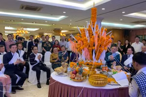 Các đại biểu dự lễ buộc chỉ cổ tay trong Tết cổ truyền Bunpimay của Lào. 