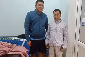 Ông Trương Văn Duy (bên phải) được cán bộ Điện lực Lệ Thủy cứu sống sau hơn 12 giờ đồng hồ đu trên cột điện giữa mênh mông nước lũ.