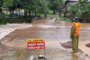 Một tuyến đường ở xã Thượng Trạch, huyện Bố Trạch bị ngập sâu, lực lượng chức năng đặt biển cảnh báo và chốt trực không cho người qua lại.