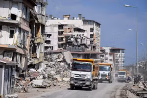 Đoàn xe tải được huy động vào thành phố để dọn dẹp đống đổ nát. (Ảnh THÀNH ĐẠT)