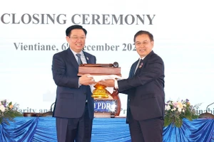 Chủ tịch Quốc hội Vương Đình Huệ nhận búa đảm nhận chức Chủ tịch Hội nghị cấp cao Quốc hội ba nước CLV lần thứ hai từ Chủ tịch Quốc hội nước Lào Saysomphone Phomvihane. (Ảnh: TTXVN)