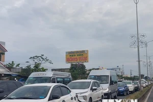 Xe ôtô nối đuôi nhau, nhích từng chút một qua cầu Rạch Miễu. (Ảnh: TTXVN)
