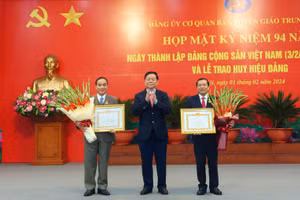 Trưởng Ban Tuyên giáo Trung ương Nguyễn Trọng Nghĩa (giữa) trao huy hiệu 40 năm tuổi Đảng tặng các đồng chí đảng viên.