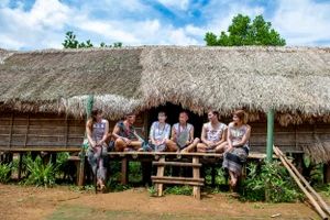 Đồng bào Mạ (Lâm Đồng) bên căn nhà Dài truyền thống (Ảnh: THÀNH ĐẠT)