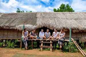 Đồng bào Mạ (Lâm Đồng) bên căn nhà Dài truyền thống (Ảnh: THÀNH ĐẠT)