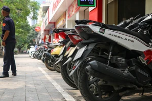 Vạch kẻ trắng phân chia chỗ để xe máy trên vỉa hè phố Láng Hạ. (Ảnh: Nhật Quang)