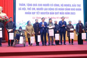 Bộ trưởng Lao động-Thương binh và Xã hội Đào Ngọc Dung, lãnh đạo tỉnh Hà Nam tặng quà gia đình chính sách tại huyện Lý Nhân nhân dịp Tết Nguyên đán Quý Mão. (Ảnh: Molisa)