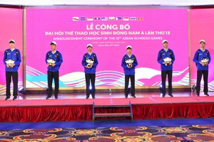 Các vận động viên cầm trên tay linh vật của giải đấu - voọc chà vá chân nâu. (Ảnh: Bộ Giáo dục và Đào tạo)