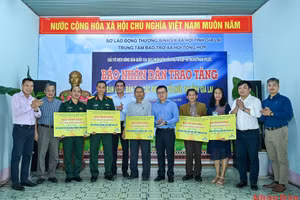 Tổng Biên tập Báo Nhân Dân Lê Quốc Minh cùng các đại biểu và nhà tài trợ trao tặng bàn bóng bàn cho các đơn vị. 