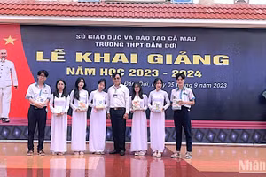 Hiệu trưởng Trường Trung học phổ thông Đầm Dơi (Cà Mau) trao tặng tập học sinh vận động từ Báo Nhân dân cho học sinh vượt khó học giỏi tại địa phương. 