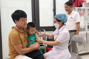 Người dân trên địa bàn Hà Nội đưa trẻ đi tiêm vaccine phòng bệnh sởi.
