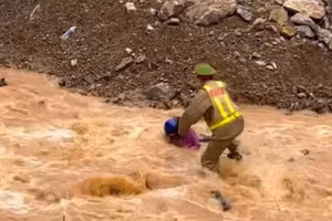 Thượng úy Nguyễn Mạnh Tường lao ra giữa dòng nước xiết cứu người. (Ảnh cắt từ clip)