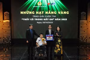 Thứ trưởng Giáo dục Ngô Thị Minh và Chủ tịch Công đoàn Giáo dục Việt Nam Nguyễn Ngọc Ân trao giải đặc biệt tặng em Nguyễn Minh Kiệt, Trường Trung học cơ sở Chương Dương, Hoàn Kiếm, Hà Nội và thầy giáo của mình.