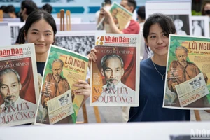 Các bạn trẻ hào hứng cầm trên tay ấn phẩm đặc biệt của Báo Nhân Dân. (Ảnh: SƠN TÙNG)