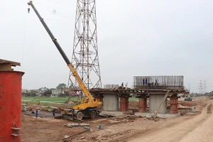 Công nhân thi công phần trụ cột cầu Kênh Vàng. (Ảnh TTXVN)