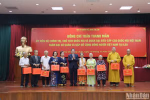 Chủ tịch Quốc hội tặng quà đại diện cộng đồng người Việt Nam tại Lào. (Ảnh: HẢI TIẾN)