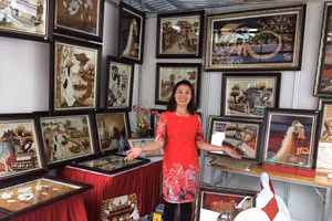Chị Nguyễn Thị Vân, xã Đông Xuân, huyện Sóc Sơn (Hà Nội) bên các tác phẩm tranh gạo.