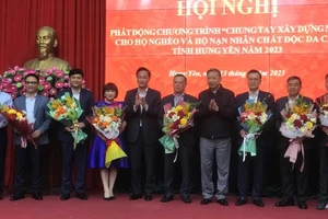 Bộ trưởng Công an Tô Lâm tặng hoa cho đại diện các tổ chức kinh tế, doanh nghiệp đã tài trợ xây nhà ở cho hộ nghèo, hộ nạn nhân chất độc da cam ở tỉnh Hưng Yên.