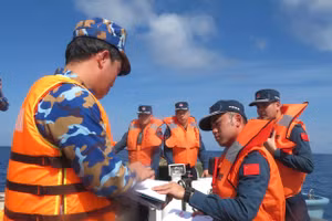 Hải quân Trung Quốc và Việt Nam ký hồ sơ bàn giao 2 ngư dân gặp nạn trên biển. 