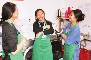 Lương Thị Kiều Thúy (người đứng giữa) trao đổi công việc cùng các đồng nghiệp. 