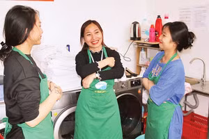 Lương Thị Kiều Thúy (người đứng giữa) trao đổi công việc cùng các đồng nghiệp. 