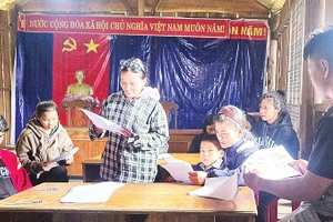 Người dân thôn Vi Xây, xã Ðăk Tăng, huyện Kon Plông tìm hiểu về động đất qua Sổ tay hướng dẫn về ứng phó với động đất. 