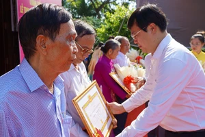 Bí thư Tỉnh ủy Đồng Tháp Lê Quốc Phong trao Huy hiệu Đảng cho các đảng viên. (Ảnh: HỮU NGHĨA)