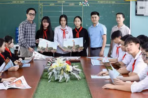 Đại diện Văn phòng Báo Nhân Dân tại Lạng Sơn trao ấn phẩm đặc biệt" Cột cờ Hà Nội" cho giáo viên và học sinh trường Trung học sơ sở thị trấn Bắc Sơn, huyện Bắc Sơn (Lạng Sơn).