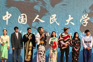 Hoàng Thị Hạnh Trang (thứ tư từ phải sang) cầm cờ Tổ quốc trong một sự kiện giao lưu văn hóa ở Bắc Kinh.