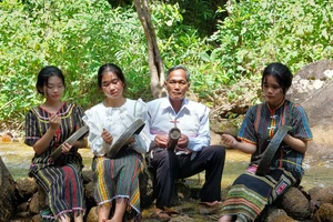 Nghệ nhân K’Trời dạy các cháu học sinh chơi cồng chiêng.