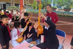 Nghệ nhân Thùng Văn Đôi giới thiệu các bộ phận cây đàn tính của đồng bào dân tộc Thái đến học sinh Trường phổ thông dân tộc bán trú tiểu học Chà Nưa. 