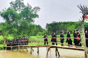 Người Xuân Dương đi qua dòng Bắc Sen để đến chợ tình hát Sli. Ảnh: CÔNG LUẬN