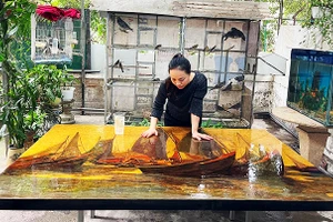 Họa sĩ đang hoàn thành một bức tranh khổ lớn.