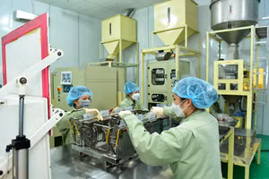 Đóng gói gạo "Sức sống Mekong" tại Nhà máy lương thực Vĩnh Hưng (huyện Vĩnh Hưng, Long An).