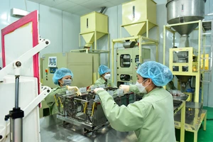 Đóng gói gạo "Sức sống Mekong" tại Nhà máy lương thực Vĩnh Hưng (huyện Vĩnh Hưng, Long An).