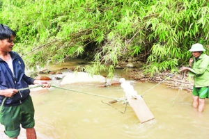 Già làng A Cho (bên phải) tìm địa điểm phù hợp để đặt chiếc “cà xạt” mới.