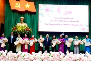 Lãnh đạo tỉnh tặng hoa chúc mừng 10 gương mặt “Phụ nữ tiêu biểu vì cộng đồng” được tuyên dương năm nay.