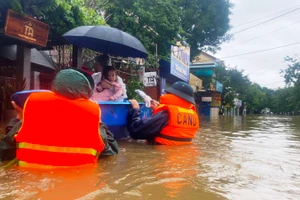 Cán bộ, chiến sĩ ngâm mình trong nước di dời người dân vùng ngập lũ ở Huế.