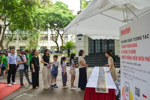 Bạn đọc xếp hàng để nhận ấn bản đặc biệt của Báo Nhân Dân in tranh panorama Chiến dịch Điện Biên Phủ.