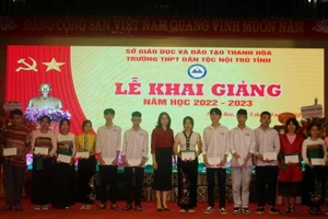 Đại diện doanh nghiệp trao tặng học bổng cho học sinh học tập tốt.