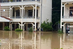 Các em học sinh phải di dời do nước lũ ngập cao.