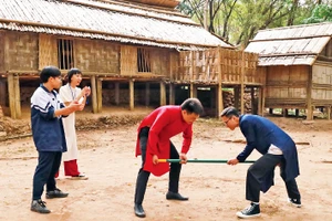 Khách tham quan tham gia trò chơi gậy của người dân tộc Mông. 