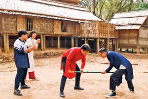 Khách tham quan tham gia trò chơi gậy của người dân tộc Mông. 