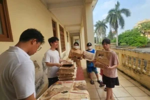 Sinh viên Đại học Y Hà Nội và Học viện Tài chính hỗ trợ phát phụ san cho người dân.
