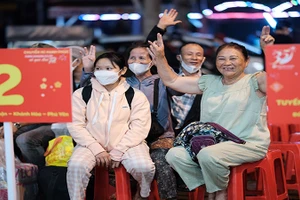 Người dân vui mừng trước khi lên “Chuyến xe hạnh phúc” để về quê đón Tết.