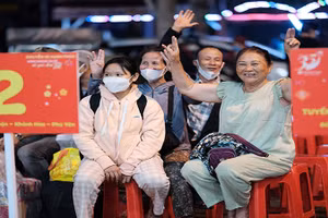 Người dân vui mừng trước khi lên “Chuyến xe hạnh phúc” để về quê đón Tết.