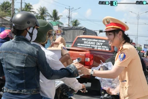 Cảnh sát giao thông (Công an Tiền Giang) tặng nước uống cho người dân. 