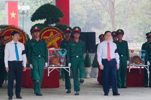 Đồng chí Nguyễn Trọng Nghĩa (phải) và Bí thư Tỉnh ủy, Chủ tịch HĐND tỉnh Tây Ninh Nguyễn Thành Tâm (trái) di an hài cốt liệt sĩ đến nơi an táng. Ảnh: TTXVN